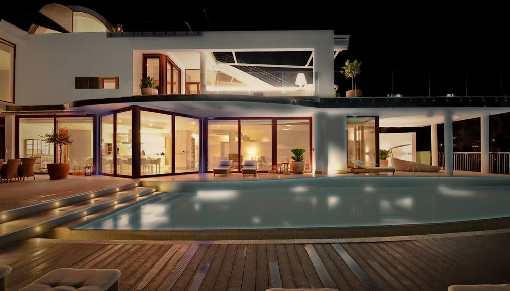 Luxury villa lit at night with pool and terrace
